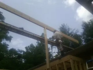 Carpenter setting a ridge beam over a new addition frame — Ice Dam Removal by Roofing Brothers in Fort Shaw