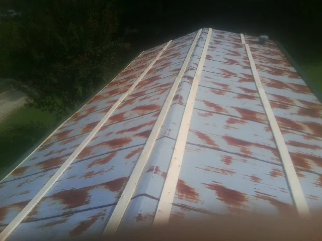Rusted metal roof panels with new wood purlins before replacement — Storm Damage Roof Repair in Fort Shaw by Roofing Brothers